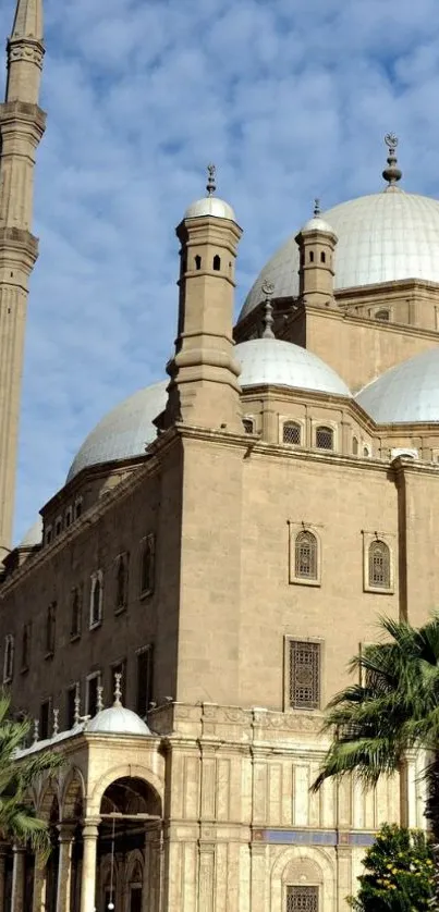 Historic mosque with domes and minarets against a blue sky.