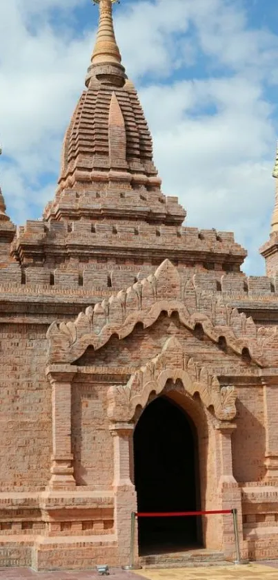 Brick-red pagoda with golden spires against a blue sky.