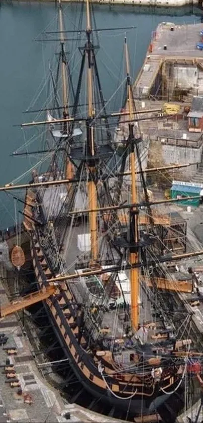 Aerial view of a historic ship docked at a bustling harbor.