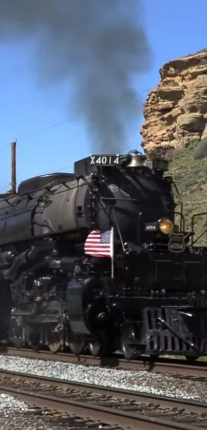 Historic steam train on railway track with scenic landscape background.