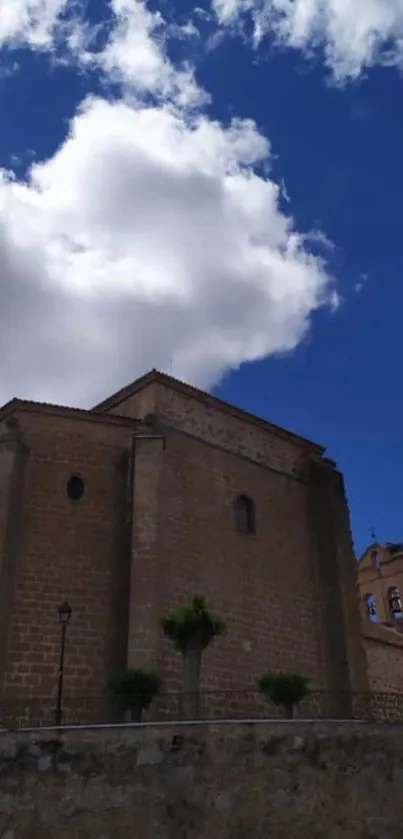 Historic stone building under cloudy blue sky.