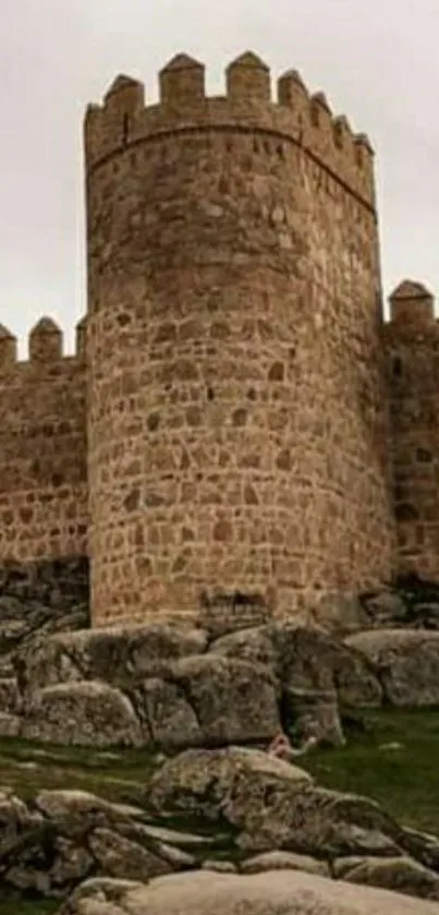 Stone fortress with rugged landscape and ancient wall.