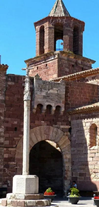 Historic red stone tower against a blue sky.