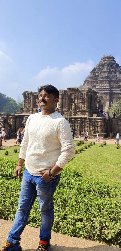 Man posing in front of historic temple with garden.