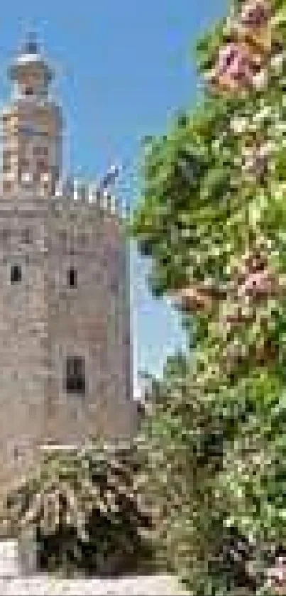 Historic tower with vibrant flowers under a clear blue sky.