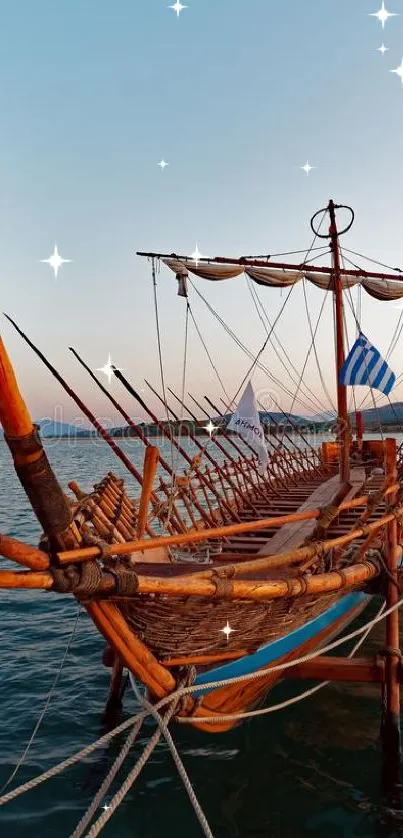 A historic wooden ship floats peacefully on calm blue waters under a clear sky.