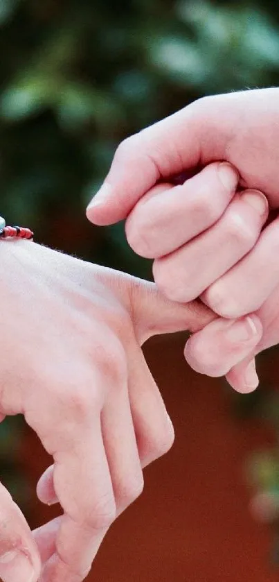 Hands crossing with delicate touch against a leafy backdrop.