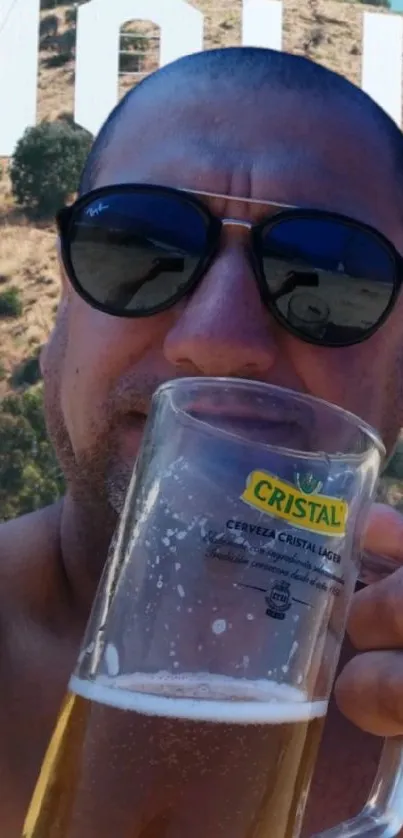 Man enjoying beer near Hollywood Sign.