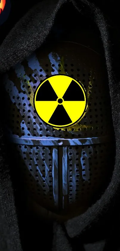 Dark hooded figure with radiation symbol on mask.