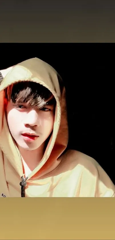 Person wearing a beige hoodie in warm light with a stylish pose.