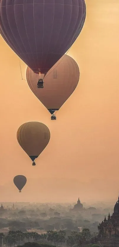 Hot air balloons floating over ancient landscape at sunrise.