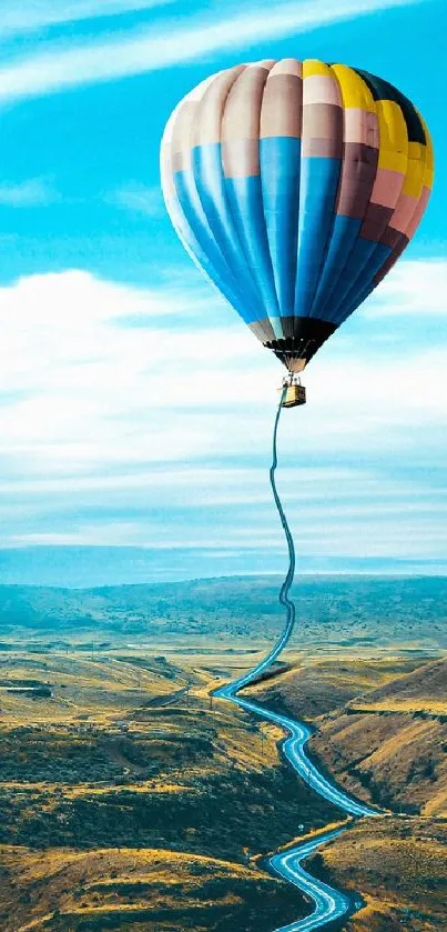 Hot air balloon over winding road under a vibrant blue sky.