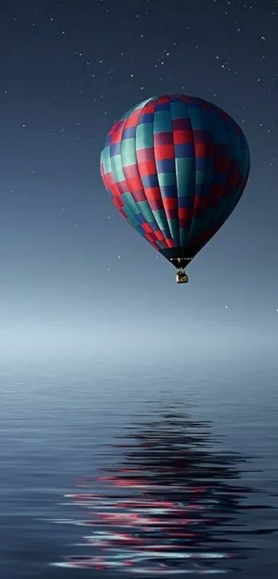 Hot air balloon drifting over starlit water at night.