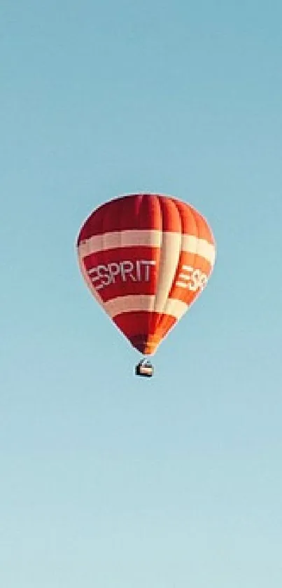 Red hot air balloon in a clear blue sky wallpaper.