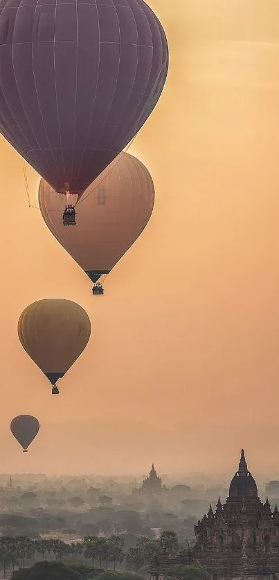 Hot air balloons float over a misty landscape at sunrise.