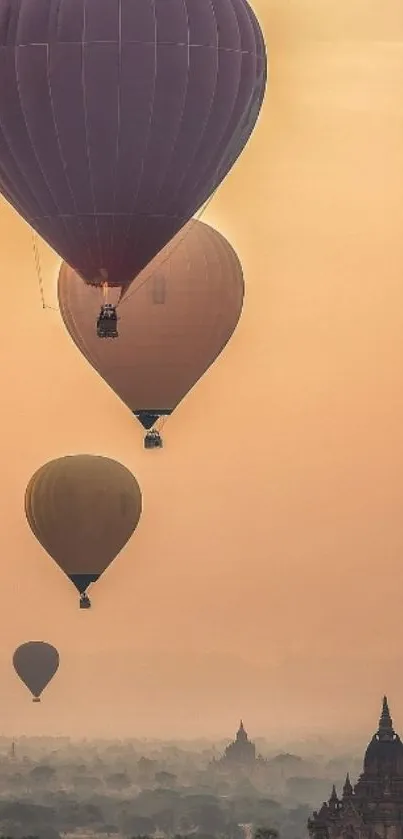 Hot air balloons rise over misty temples at sunrise in a scenic view.