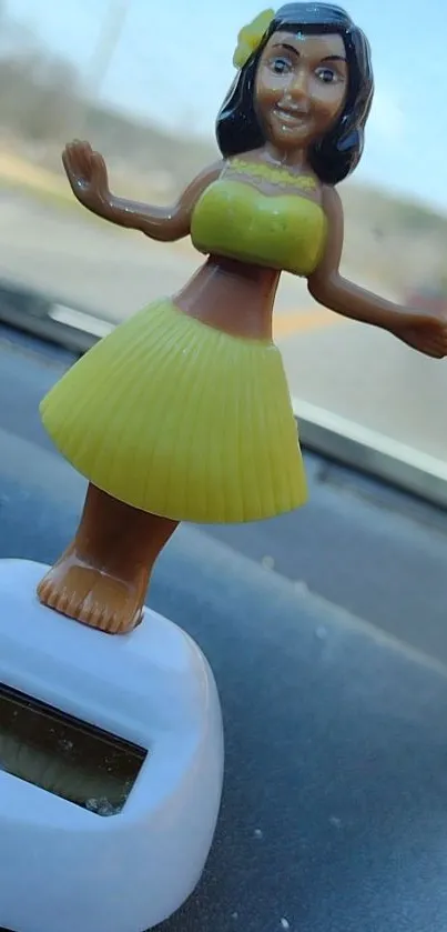 Cheerful hula dancer figurine on car dashboard.