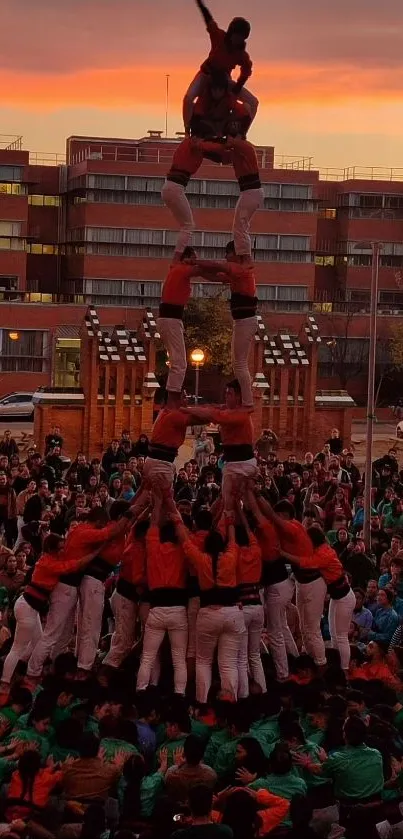 Human tower formed during sunset with cityscape backdrop.