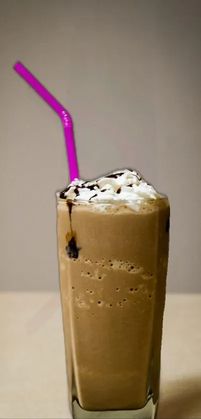 Tall iced coffee with pink straw on neutral background.