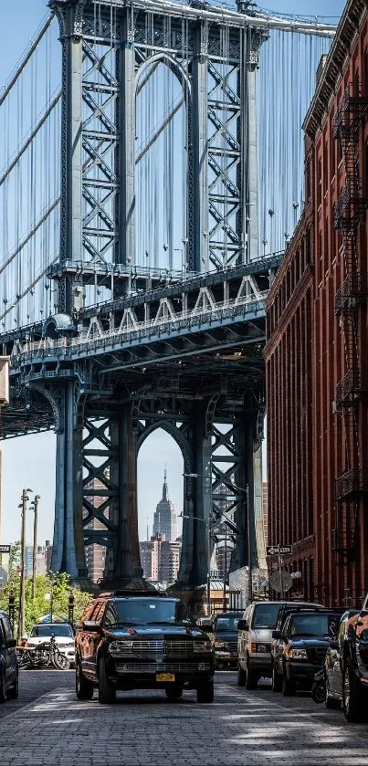 Manhattan Bridge through Brooklyn red brick buildings, blue sky in background.