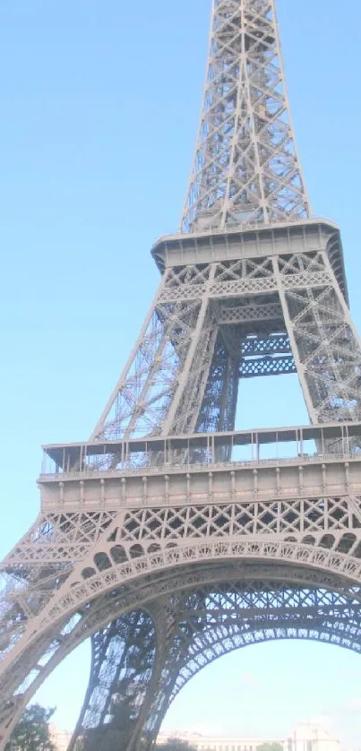 Eiffel Tower with clear blue sky background, green trees to the side.