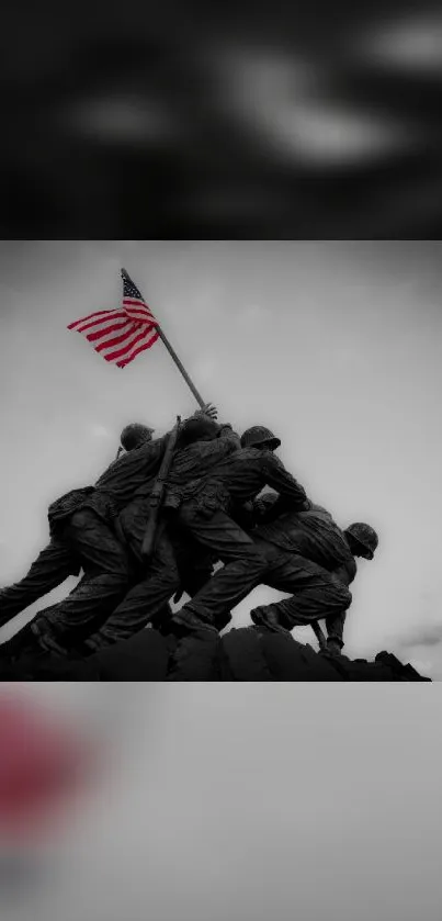 Iwo Jima flag-raising sculpture in grayscale with vivid flag.