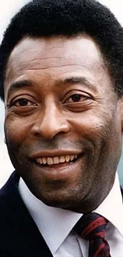 Portrait of a smiling football legend in a suit.