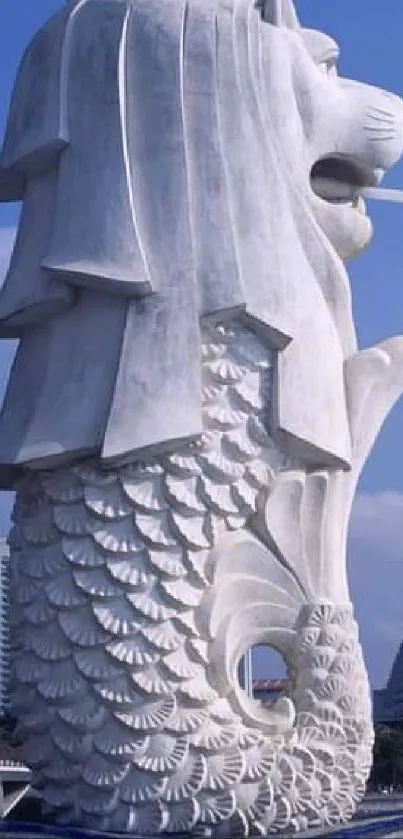 The Merlion statue overlooking Singapore's modern skyline under a bright blue sky.