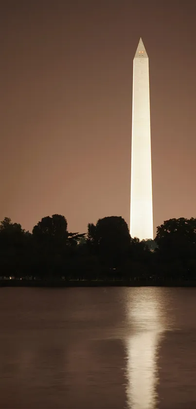 Washington monument reflecting in water at night, creating a serene scene.