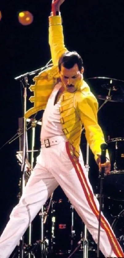 Performer in yellow jacket on stage in dynamic pose during a live concert.