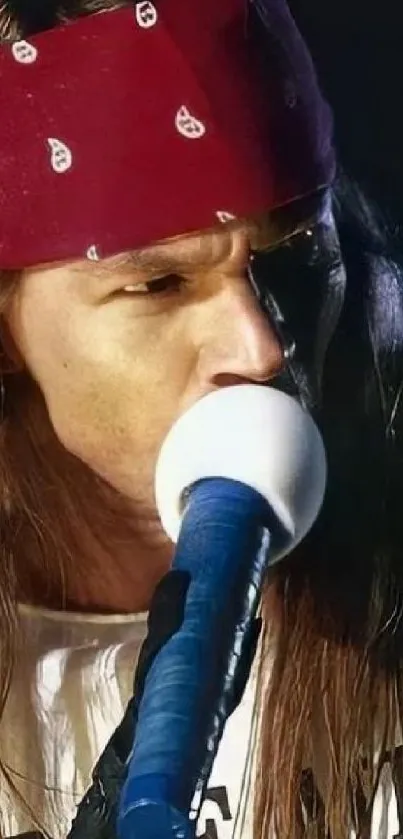 Rock musician with bandana singing on stage passionately.