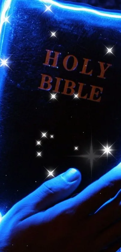 Glowing blue Holy Bible with stars illuminating a hand holding it.