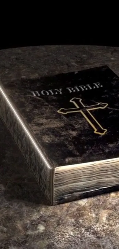 Illuminated Bible with cross on dark textured surface.