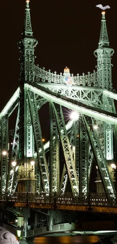 A beautifully illuminated bridge at night with city lights in the background.