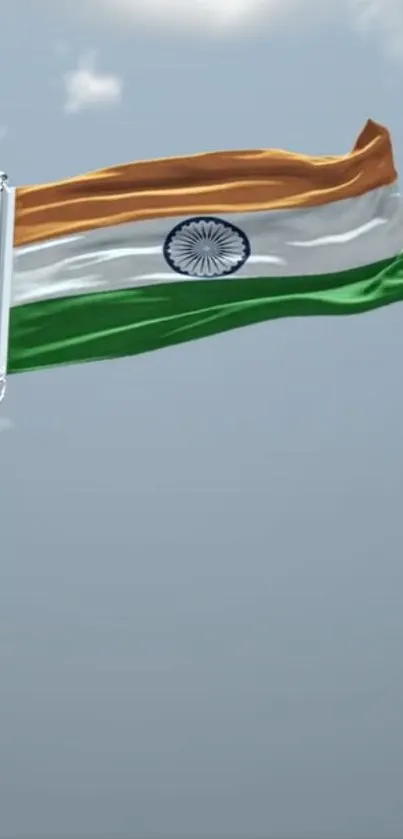 Indian flag waving against a serene blue sky.