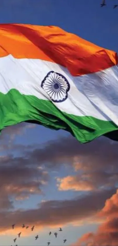 Indian flag waving against sunset sky with clouds.