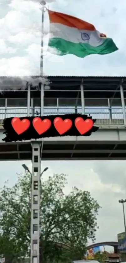 Indian flag atop bridge with cloudy sky.