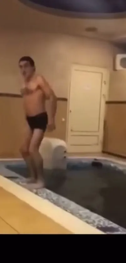 Person enjoying leisure time by a small indoor pool.