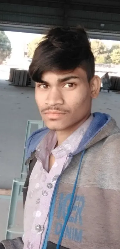 Industrial setting with young man taking a selfie in a warehouse.