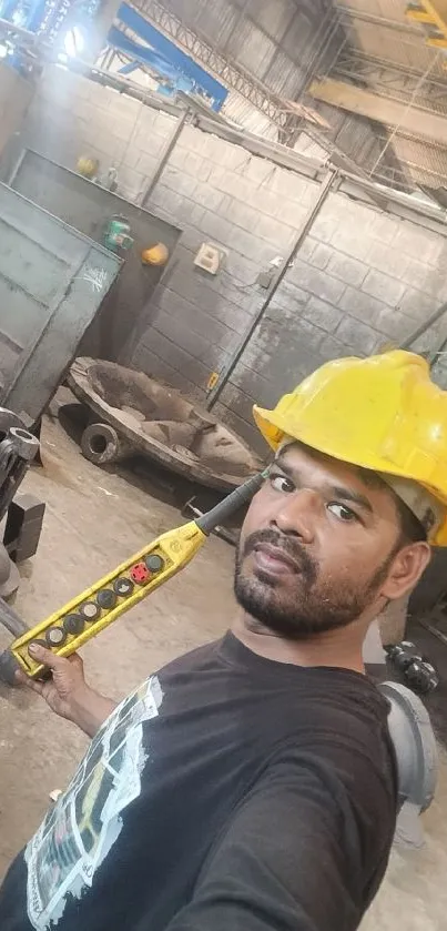 Worker with helmet taking selfie in workshop.