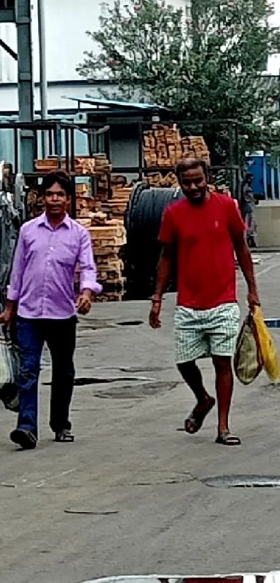 Men walking through an industrial yard with equipment in the background.