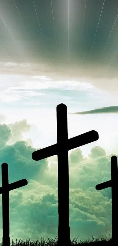 Silhouetted crosses against a cloudy teal sky.