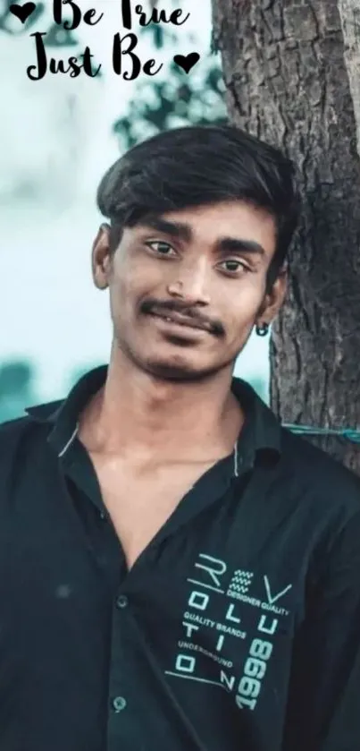 Inspirational portrait of a person leaning against a tree.