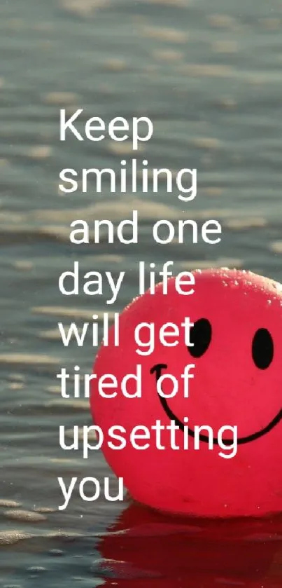 Pink smiley face on beach with inspirational quote.