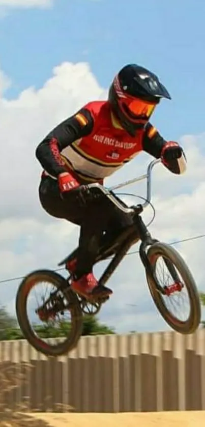 BMX rider jumping in a dirt race track under a blue sky.