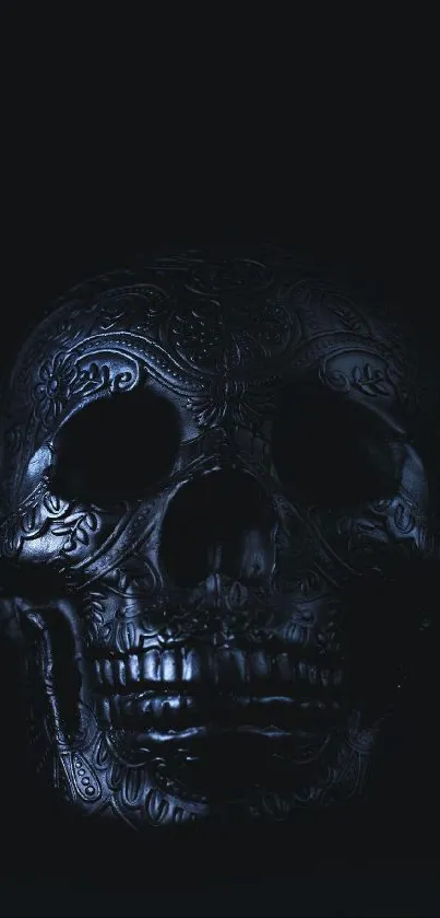 Intricate carved dark skull on a black background.