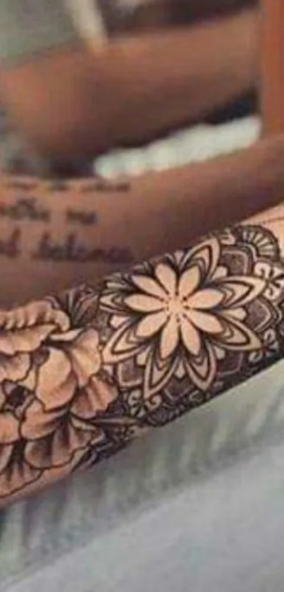 Mobile wallpaper of a detailed floral tattoo on an arm.