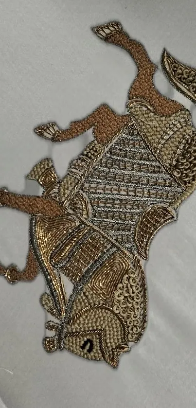 Intricate embroidery depicting a horse in beige and brown tones on light fabric.