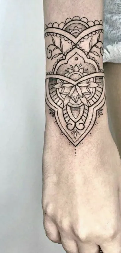 Intricate mandala tattoo design on arm with geometric patterns.