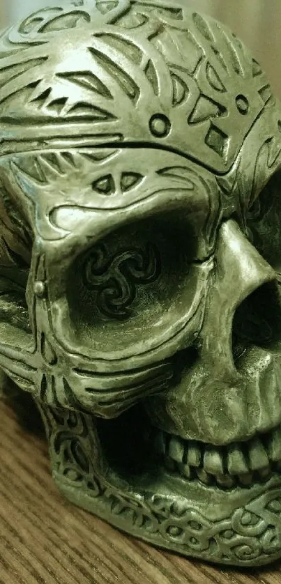 A carved skull with intricate gothic patterns on a wooden surface.